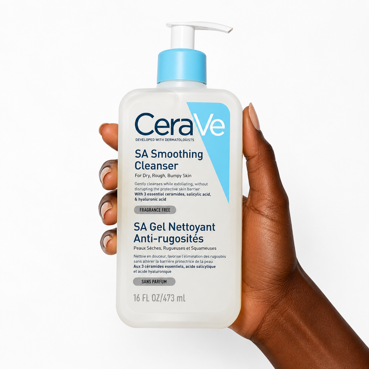 A hand holding a white bottle of CeraVe SA Smoothing Cleanser with a light blue pump dispenser against a clean white background.